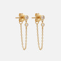 Solid Gold White Topaz Dangle Chain Huggies: elegant gold earrings, each adorned with two sparkling white topaz stones and a fine gold chain linking the bottom of the stud to the earring back.
