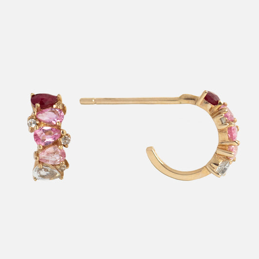 The Solid Gold Ombre Birthstone Huggie Hoops feature 9k gold and a row of pink, red, and clear gemstones along each hoop—a vibrant update to classic birthstone earrings.