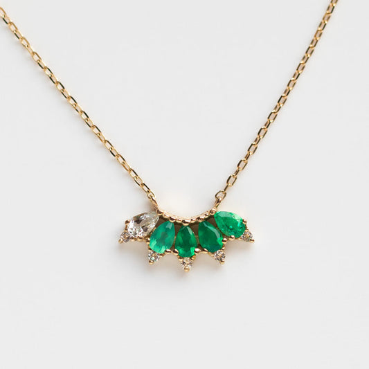 The Solid Gold Ombre Birthstone Necklace May Sample is a 9k yellow gold chain with a pendant featuring four green chalcedony teardrops and three white topaz stones in a fan shape.