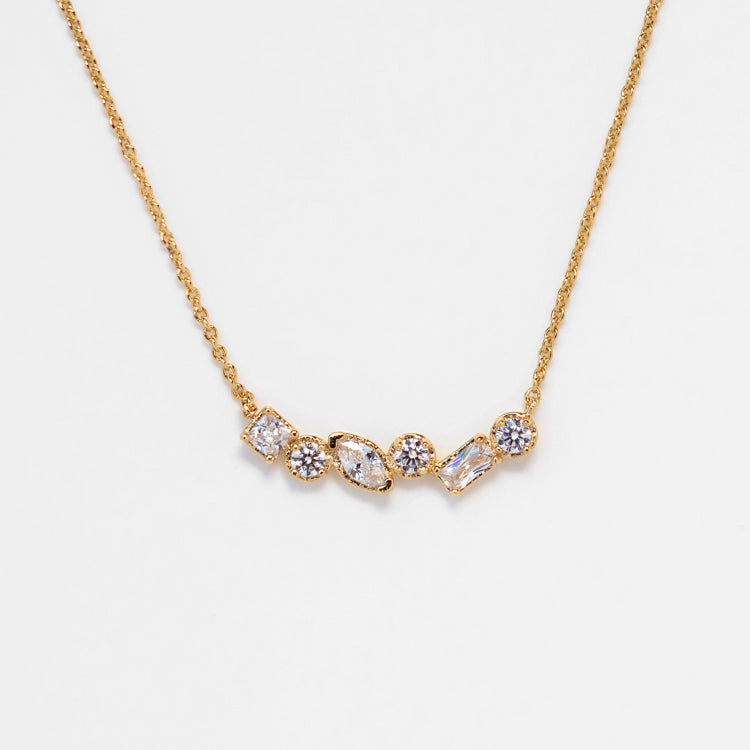 The Shades of You Ombre Birthstone Necklace features five unique gemstones in different shapes and sizes, each set in gold and arranged in a graceful curved line.