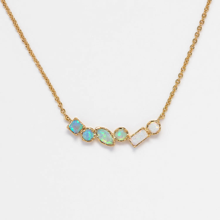 The Shades of You Ombre Birthstone Necklace features five gold-set, iridescent opal stones in unique shapes, arranged horizontally—a stunning personalized piece for any occasion.