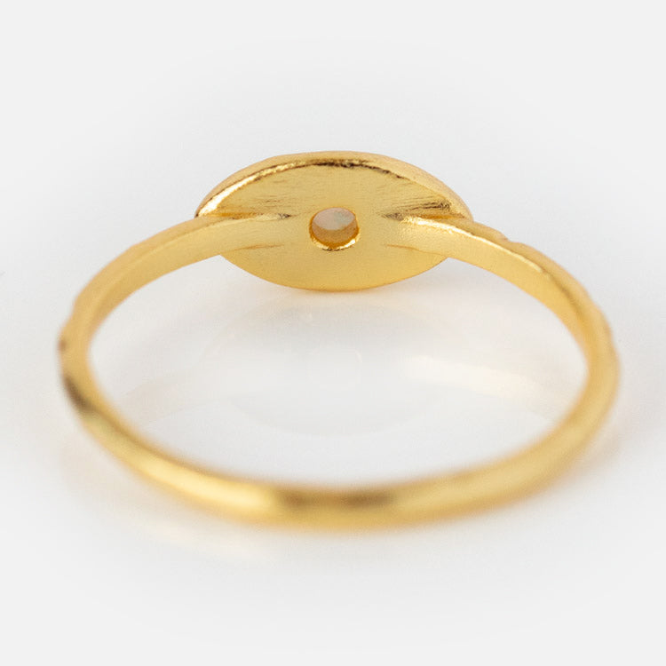 The Opal Amulet Ring is a gold plated ring with a round, flat setting and a small central hole, shown from the back on a white background—an elegant piece evocative of an evil eye design.