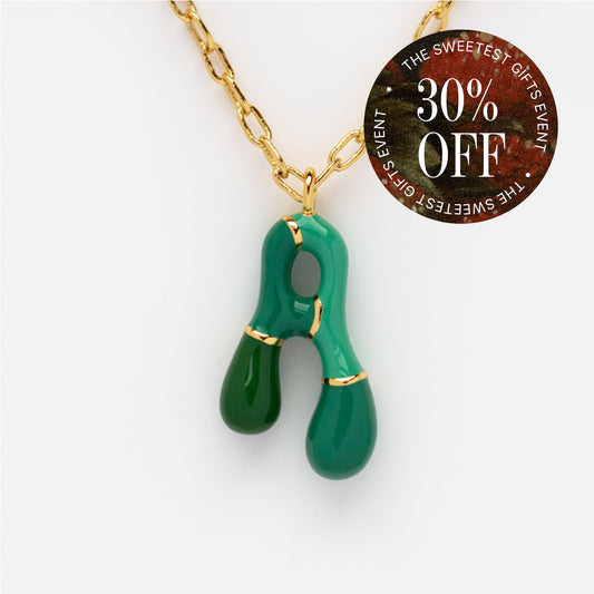 Bubble Letter Necklace: 14k gold plated chain with a glossy green abstract wishbone pendant. Colorful, playful letters. A round sticker on the right shows "30% OFF - THE SWEETEST GIFTS EVENT" in white and red text.
