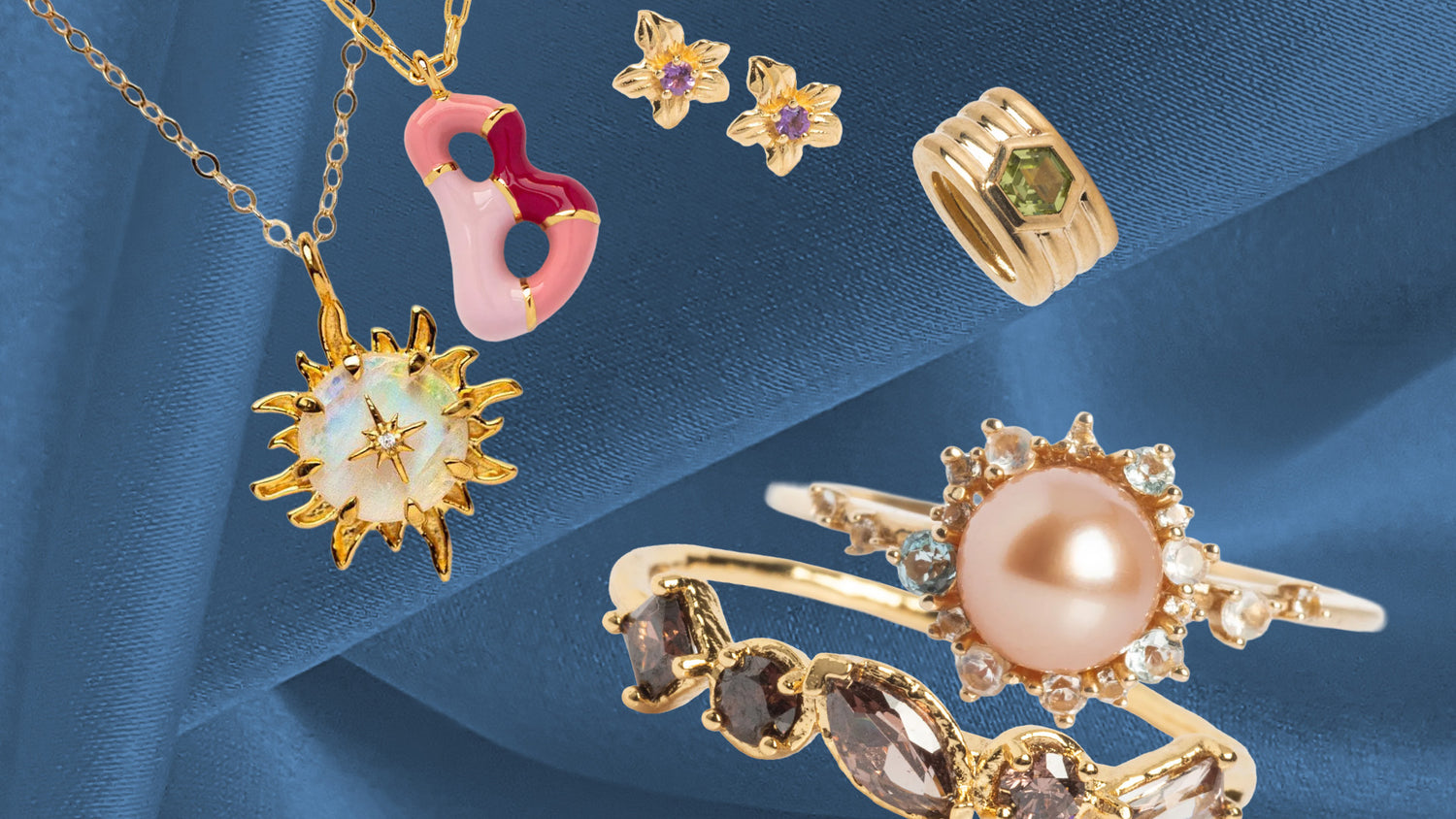 Cut outs of gold jewelry over a blue fabric background