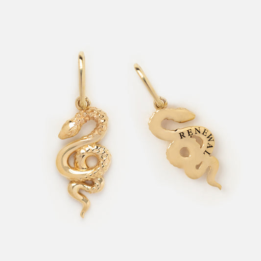 The Solid Gold Nature Charm features snake-shaped earring charms: one with a detailed textured front, the other with a smooth back engraved RENEWAL. Both include small hoops for easy attachment to earrings.