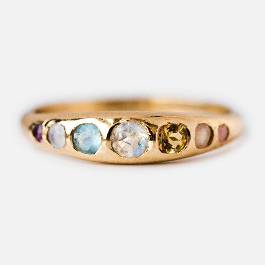 The She's an Artist Ring in Yellow Gold features six round gemstones—clear, blue, yellow, pink, and purple—set in a polished 10K yellow gold band.