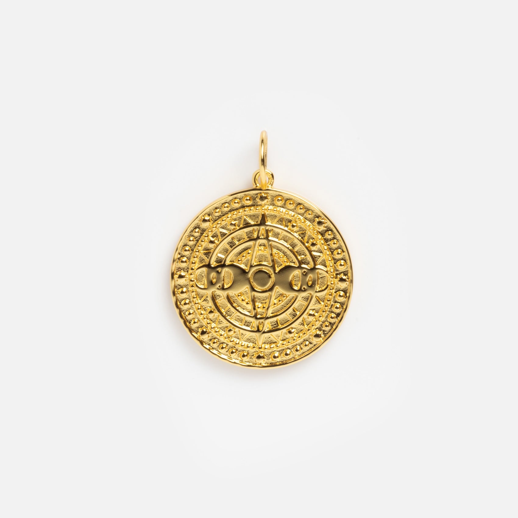 The Charms by Jurate JLA is a round yellow gold plated pendant with raised geometric and circular patterns, a small top loop for attaching to a chain, and is ideal for layering with other charms.
