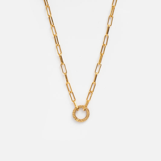 The Paperclip Charm Holder Necklace features elongated rectangular links and a textured circular pendant, shown on a plain white background.