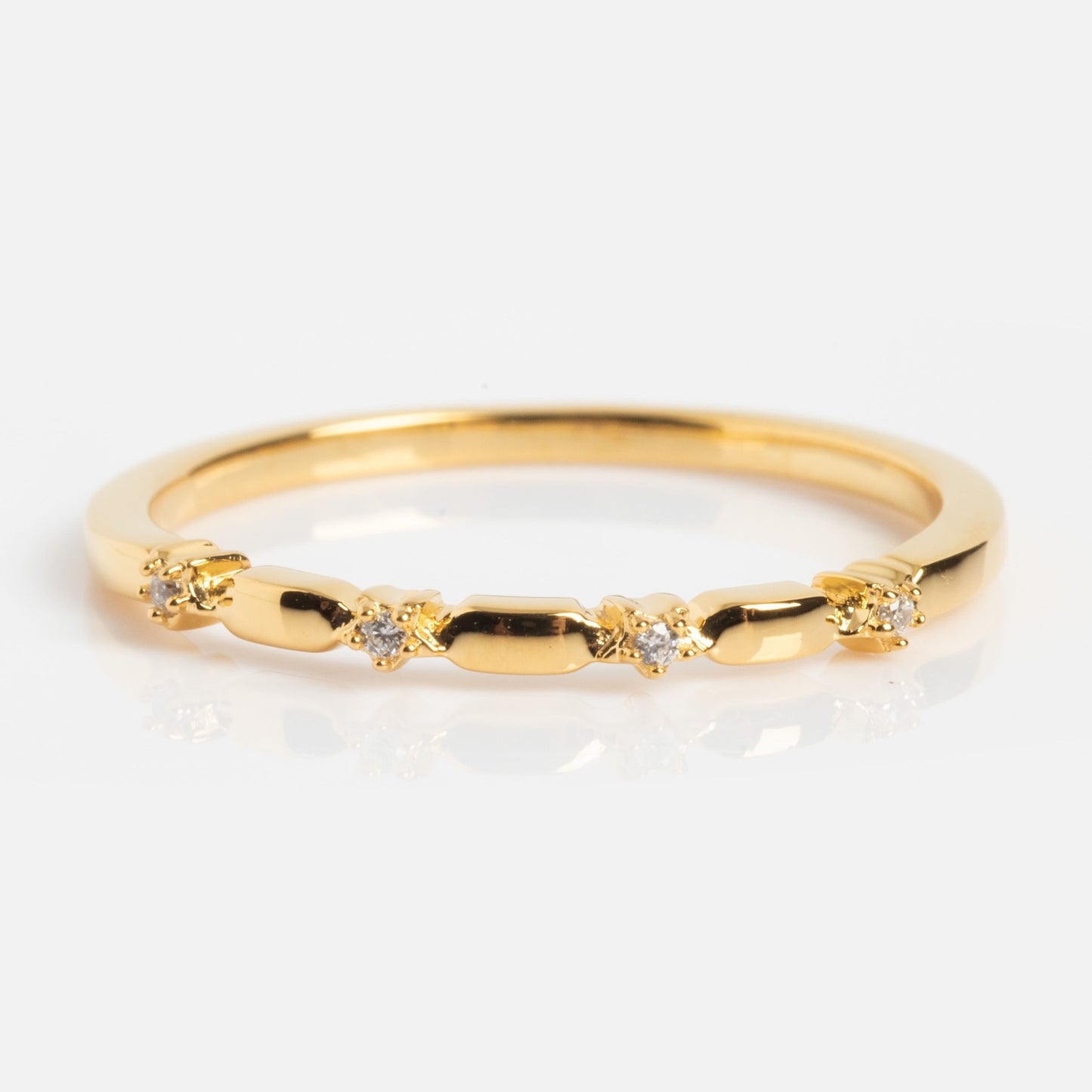 The Starry Stacking Band is a thin gold ring with small, evenly spaced round diamonds set in the band, shown on a white background.