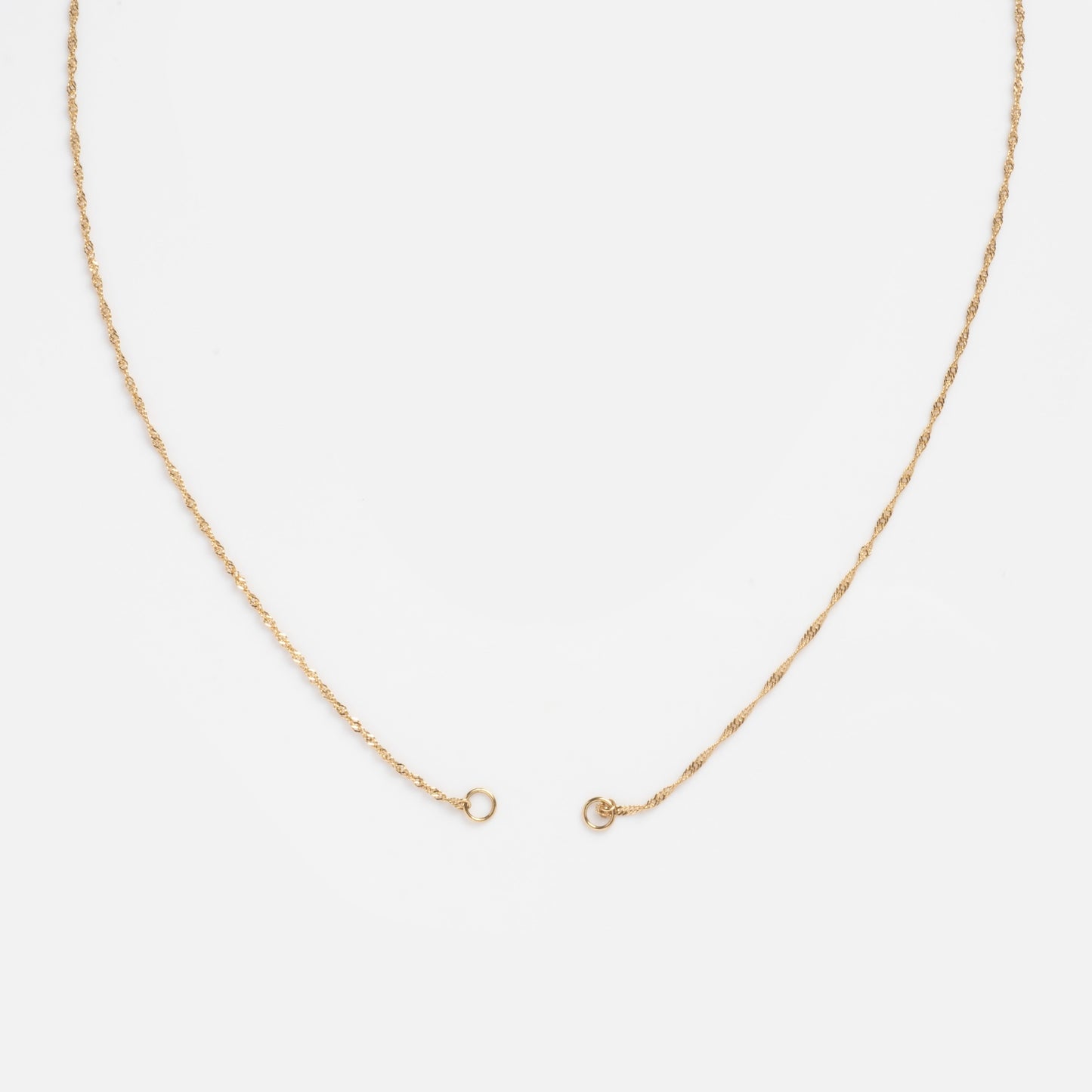 The Solid Gold Perfect Start Charm Holder Necklace, crafted in 9k gold with a simple clasp, is displayed in a wide U shape on a plain white background.