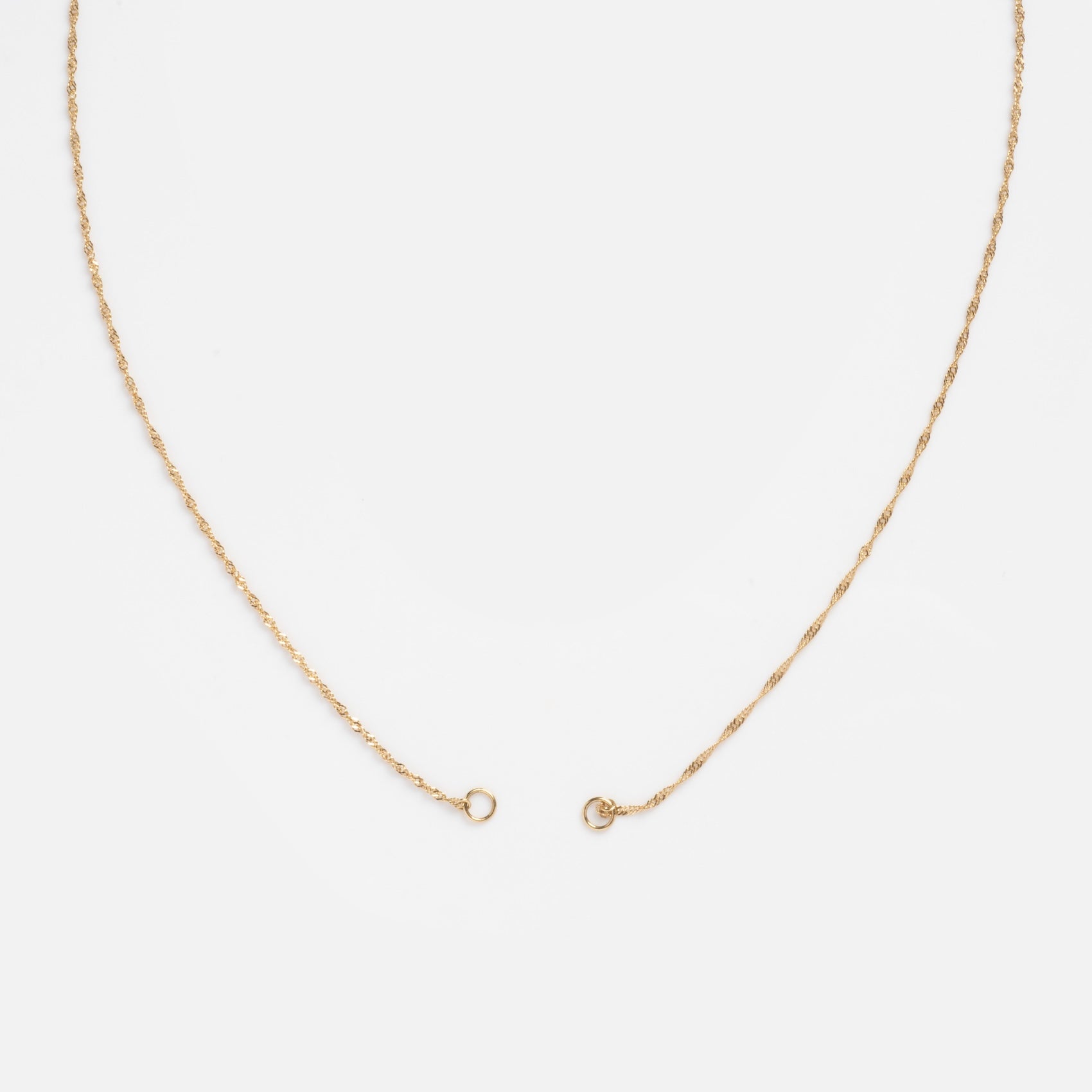 The Solid Gold Perfect Start Charm Holder Necklace, crafted in 9k gold with a simple clasp, is displayed in a wide U shape on a plain white background.
