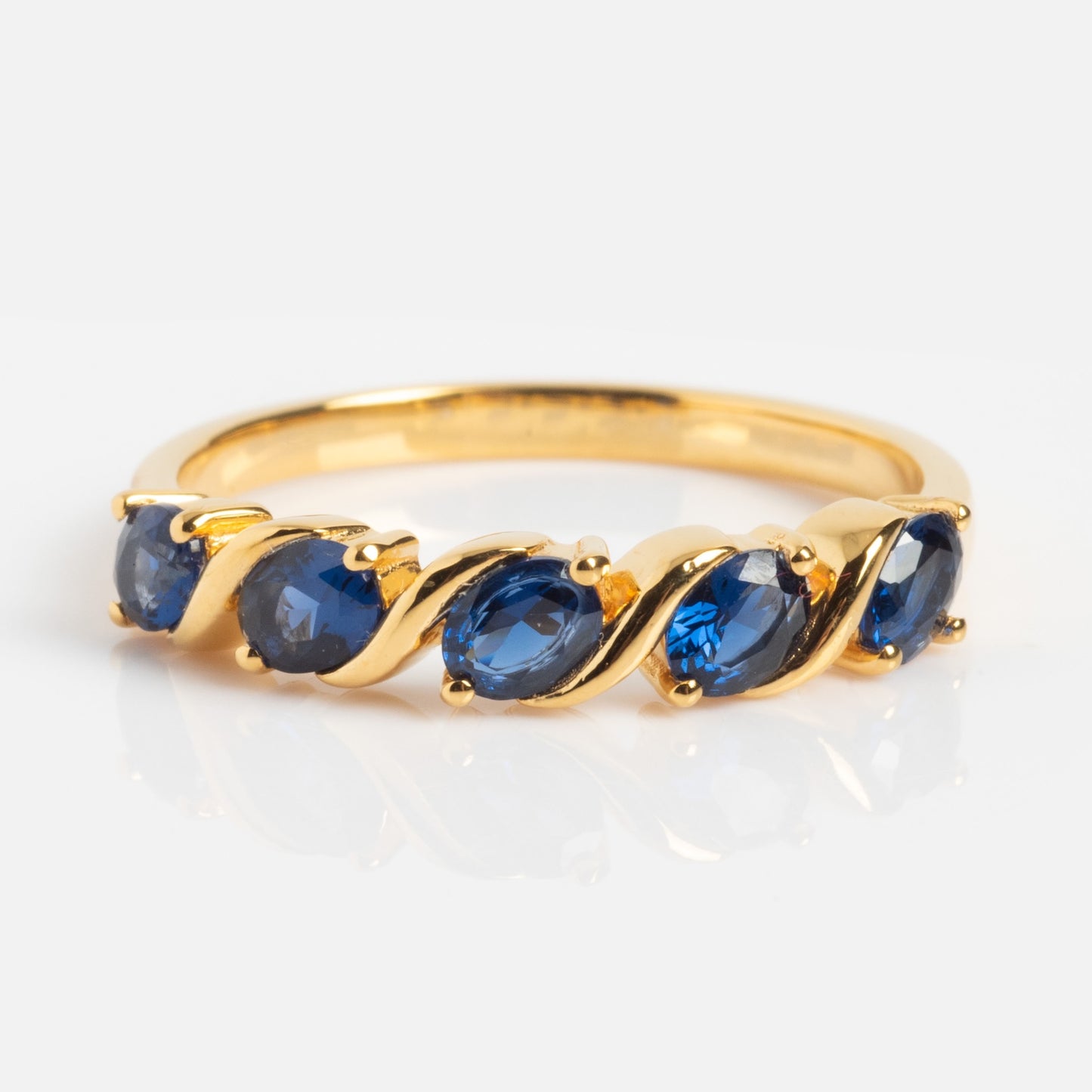 The Blue Twist Vintage Inspired Ring features five oval blue gemstones set in a twisted gold band, shown on a plain white background.