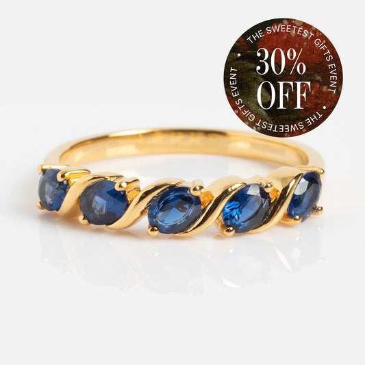 The Blue Twist Vintage Inspired Ring, featuring five oval blue jewels in yellow gold plated metal, is shown on a white background. A circular sticker at the top right says “30% OFF” and “THE SWEETEST GIFTS EVENT” in white text.