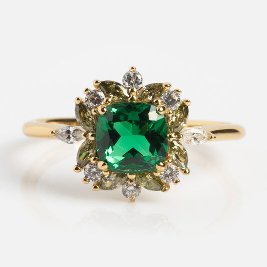 The Green Gardens Vintage Inspired Ring showcases a square-cut green gemstone at the center, accented by clear and yellow stones in a floral design.