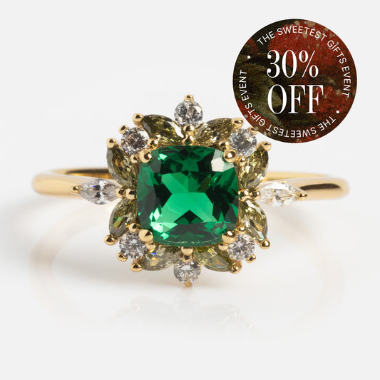 The Green Gardens Vintage Inspired Ring, featuring a yellow gold plated band with a green center stone and clear accents, is shown on a white background. A circular sticker in the corner reads "30% OFF - The Sweetest Gifts Event.