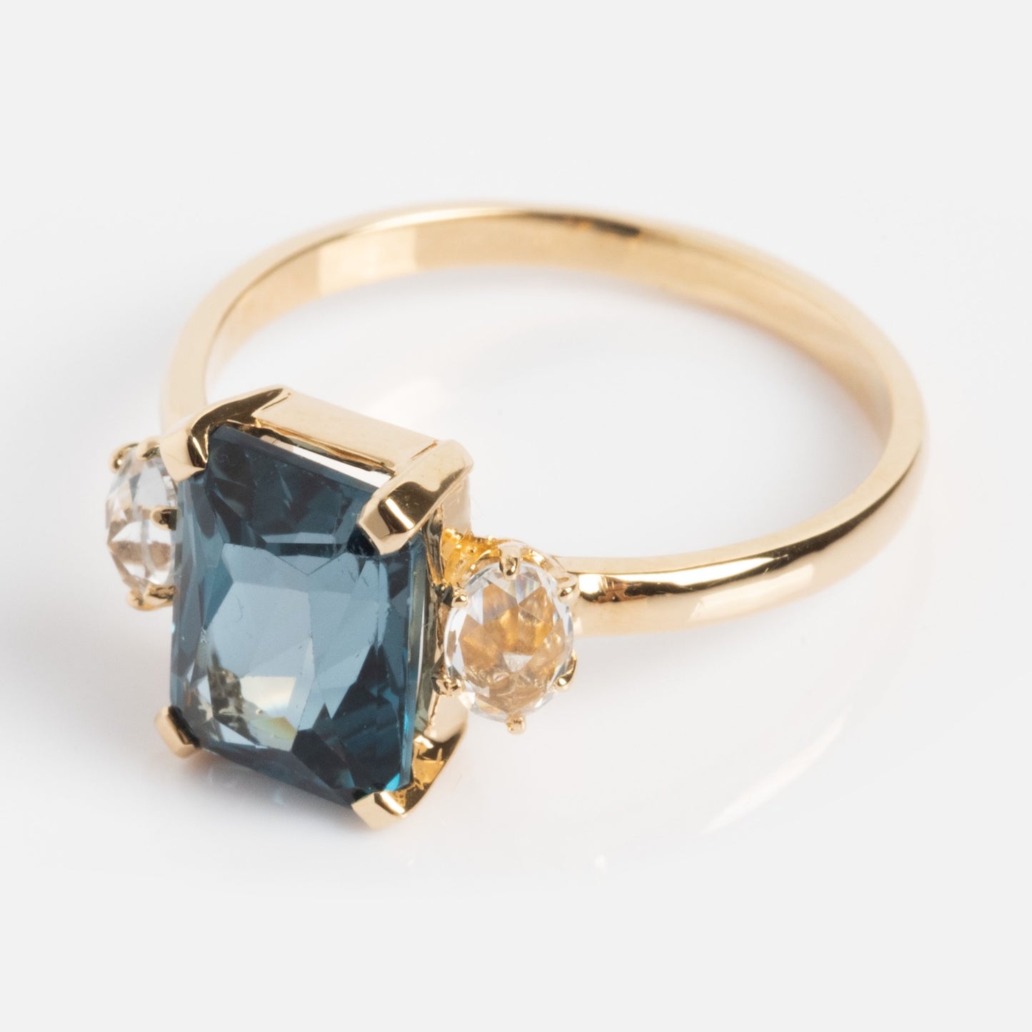 One of a Kind 14k Vintage Inspired London Blue Topaz and White Sapphire Ring with a large rectangular blue topaz center stone and two round white sapphires, shown on a plain white background.