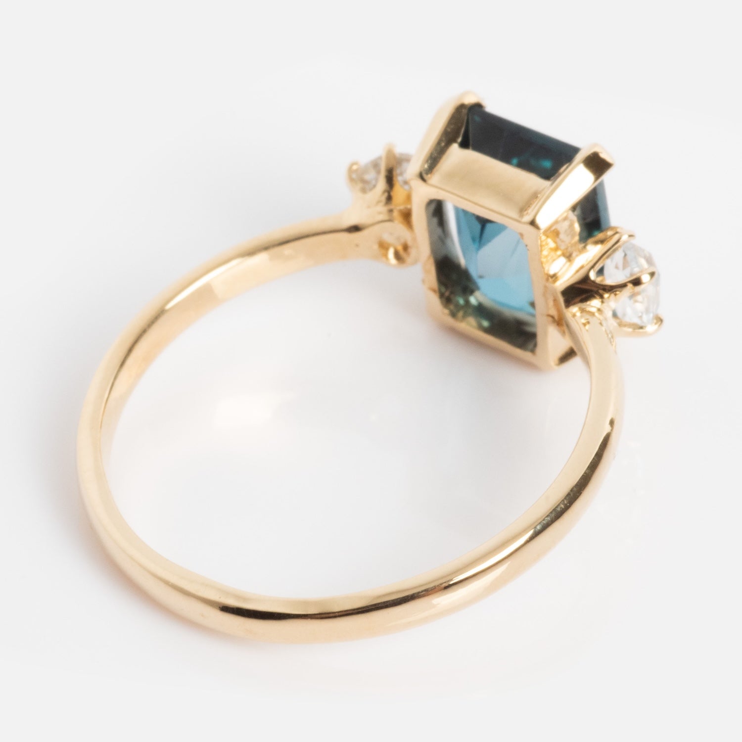 The One of a Kind 14k Vintage Inspired London Blue Topaz and White Sapphire Ring features a rectangular blue topaz center stone with two white sapphires on each side, showcased against a white background.