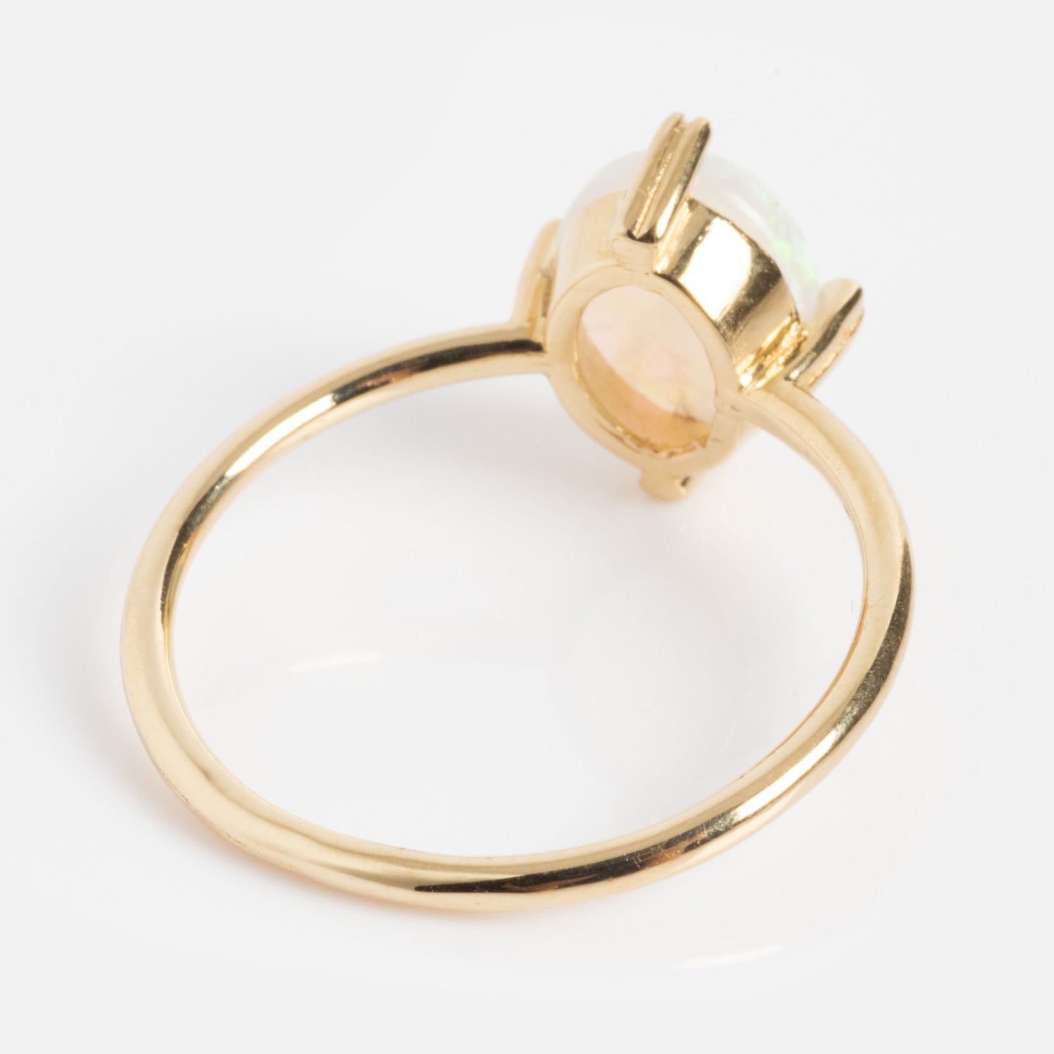 The One of a Kind 14k Heart Prong Opal Ring features a thin gold band and a large oval opal gemstone in a high heart-shaped prong setting, displayed against a white background.