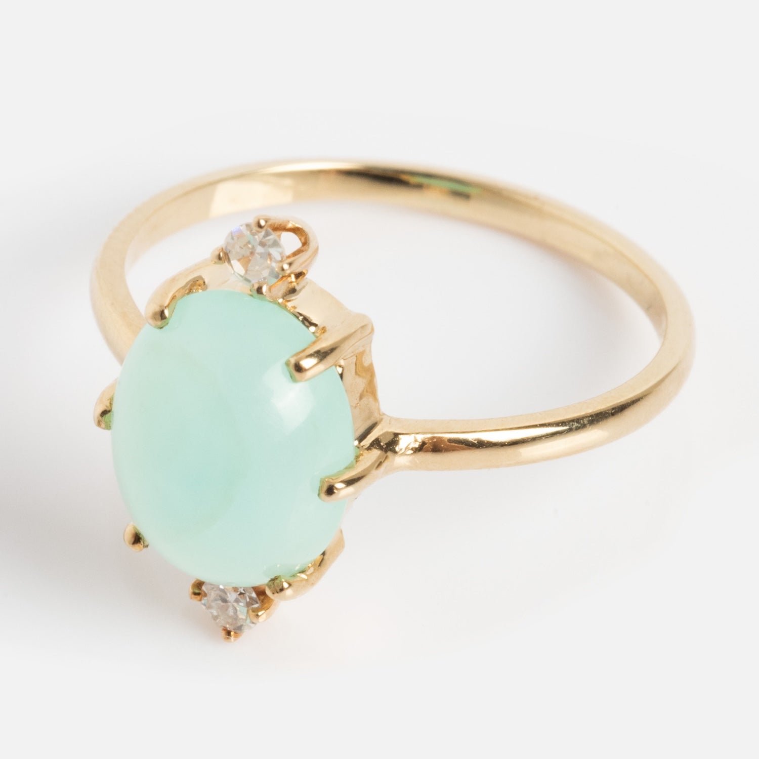 The One of a Kind 14k Peruvian Opal and Diamond Ring showcases a large oval pale green opal center, accented by two small diamonds on each side, set in gold against a plain white background.