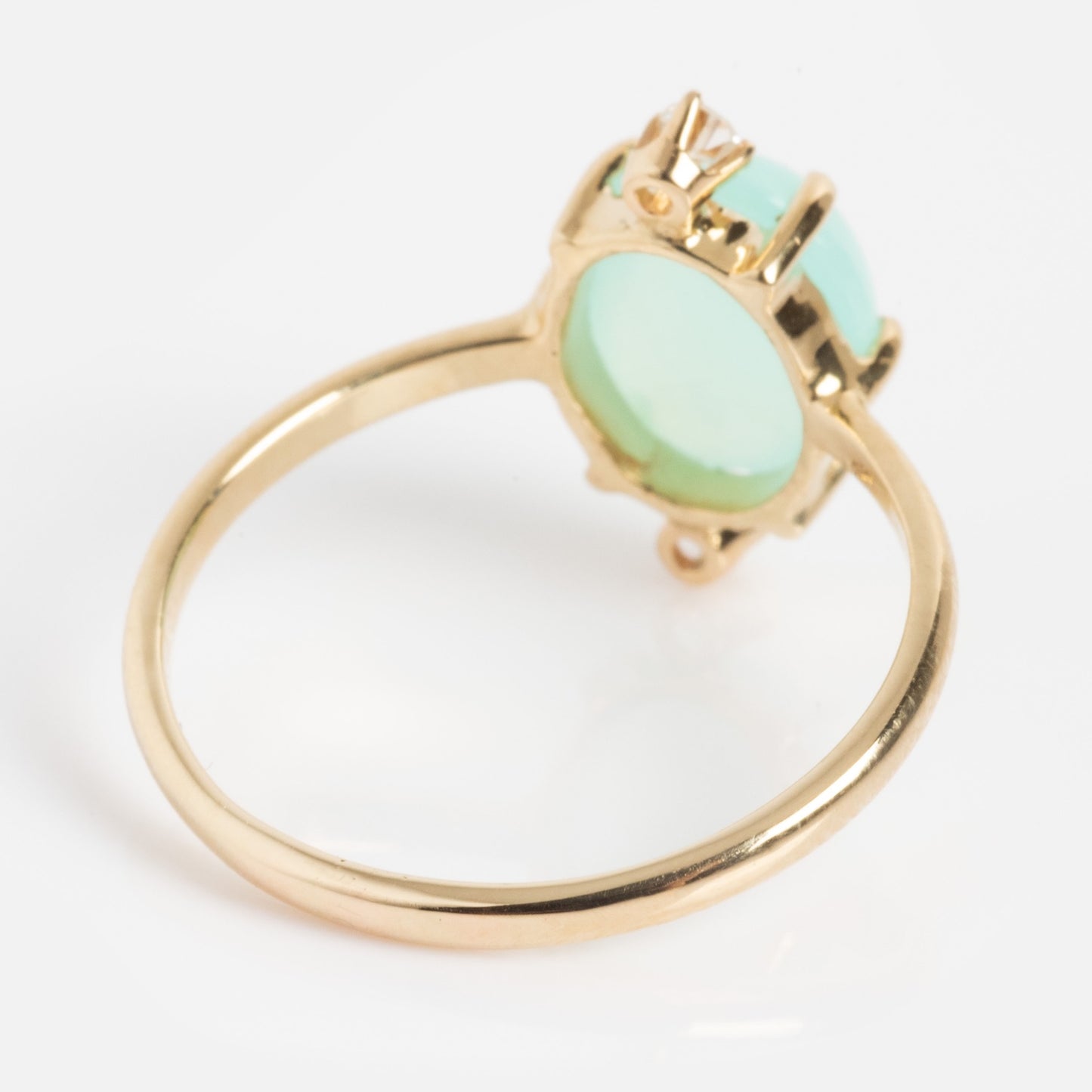 The One of a Kind 14k Peruvian Opal and Diamond Ring showcases a round, pale green Peruvian opal set in raised prongs, displayed against a white background.