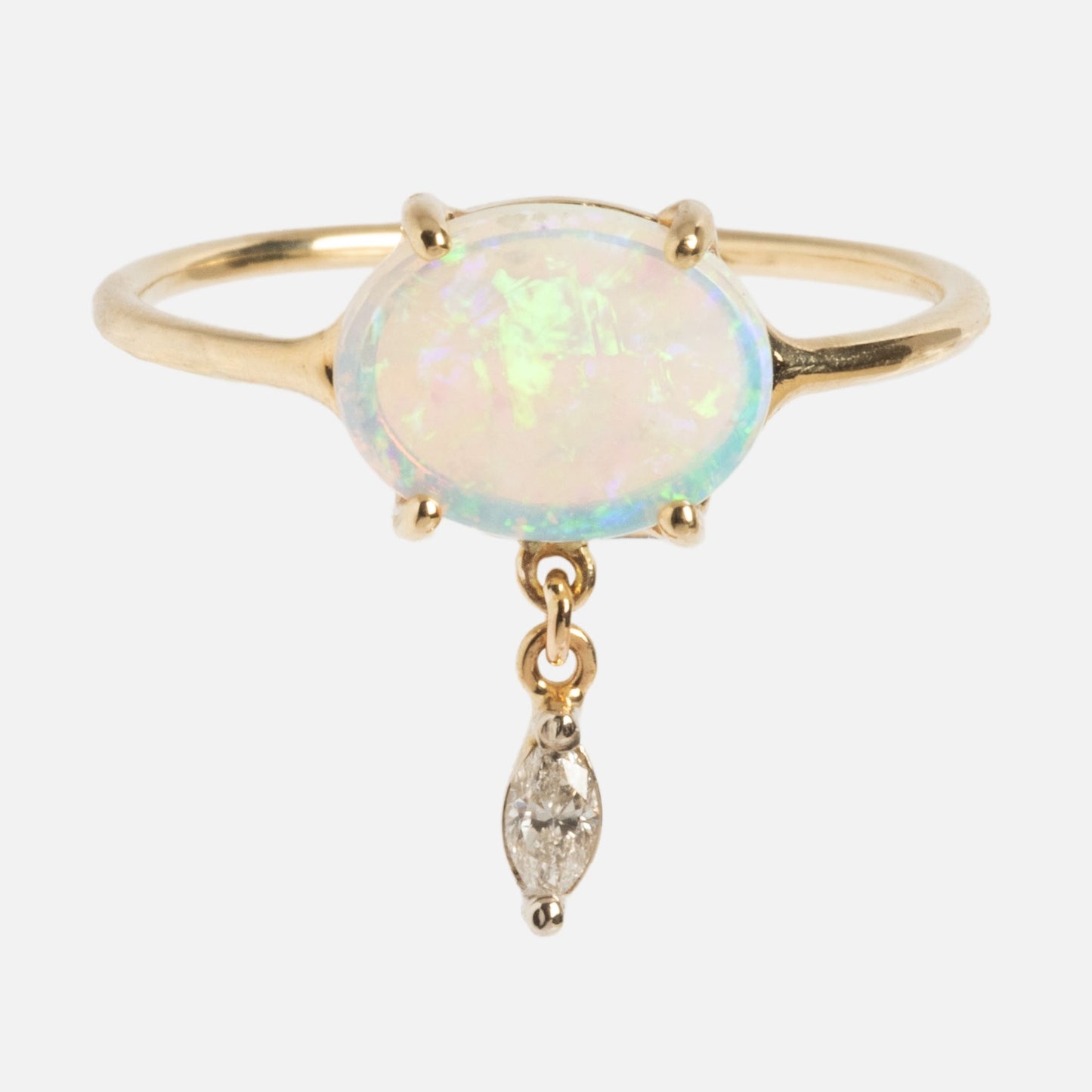 The One of a Kind 14k Opal with Diamond Dangle Ring showcases an oval opal in a prong setting, accented by a dainty marquise-shaped diamond charm hanging below the center stone.