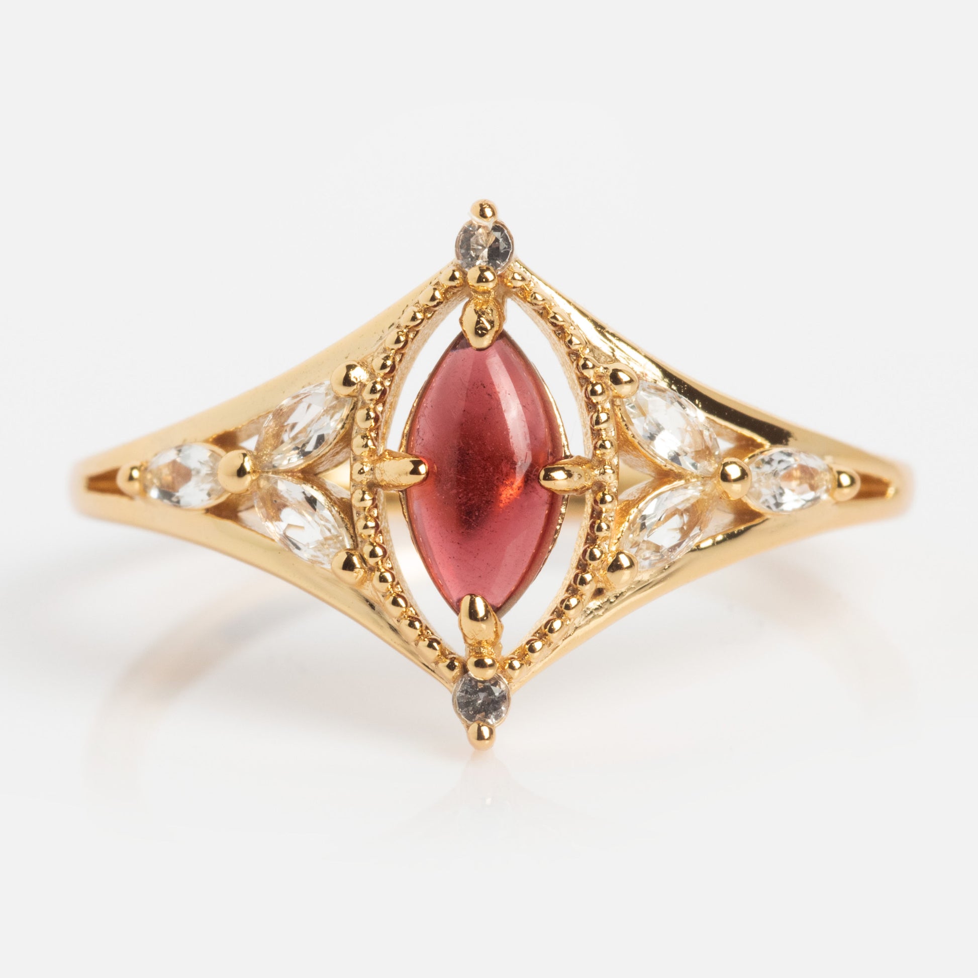 The 2026 January Capsule Art Deco Garnet Ring showcases a marquise-cut garnet in yellow gold vermeil, accented by clear marquise and round stones in a vintage-inspired design.