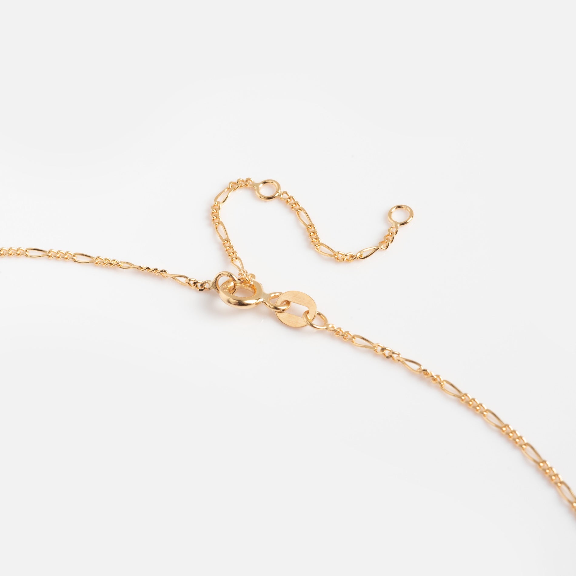 The Solid Gold Figaro Chain is a 9k yellow gold necklace featuring a lobster clasp and adjustable links, ideal for layering. Shown on a plain white background.