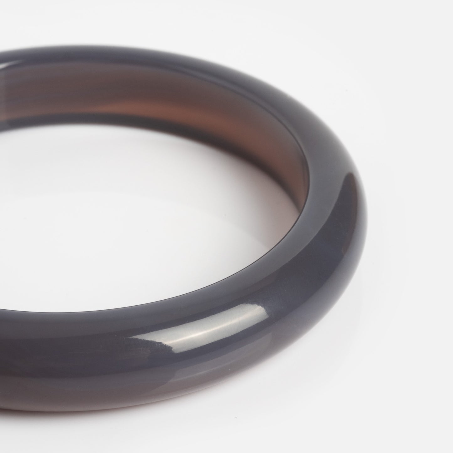 A smooth, polished Moon Purple Chalcedony Stone Bangle with a glossy dark gray finish is displayed against a plain white background.