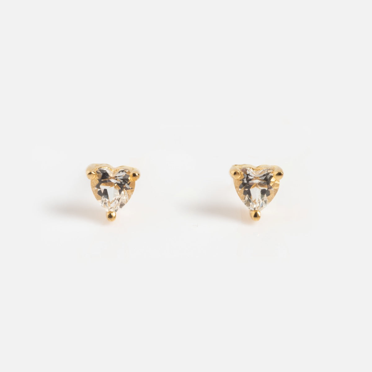 A pair of small gold stud earrings with clear, heart-shaped gemstones—perfect for pairing with the Limited Edition Valentine's Day Solid Gold Hearts Gift Set or presenting in a heart-shaped jewelry box.