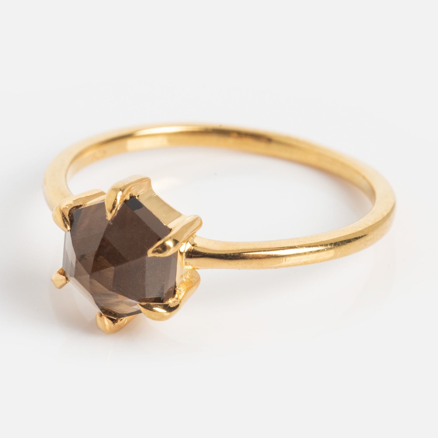 The Hexagon Smokey Quartz Ring features a prong-set, hexagon-shaped brown gemstone on a polished gold band, shown against a white background.