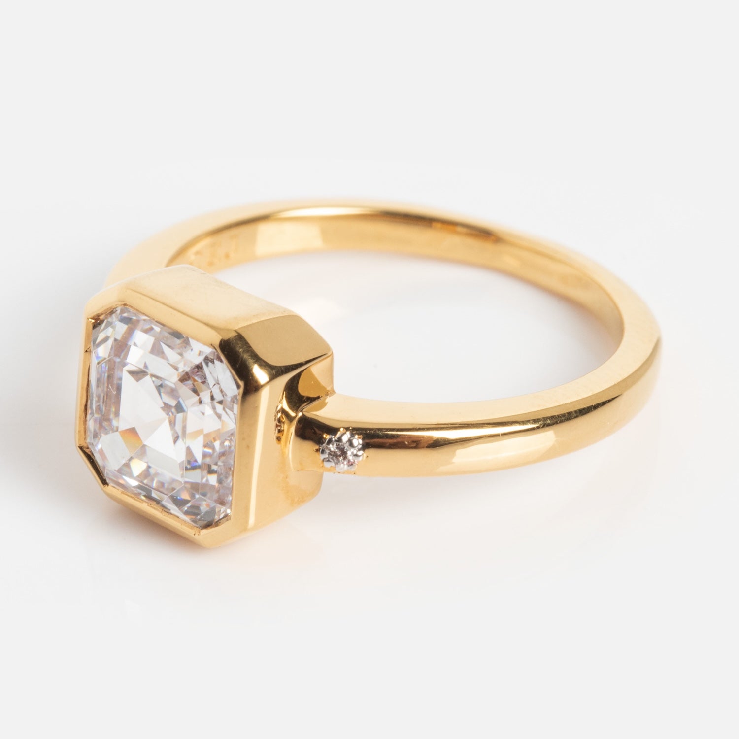 The White Topaz Statement Star Set Band is a gold ring with a large hexagonal clear gemstone in a bezel setting and a small round diamond accent on the band, shown on a white background.