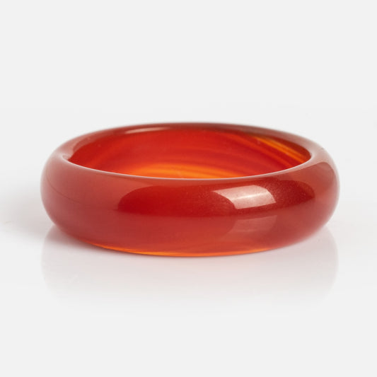 A polished, translucent Persimmon Dark Orange Agate Stone Ring with a smooth, rounded surface is shown against a plain white background.