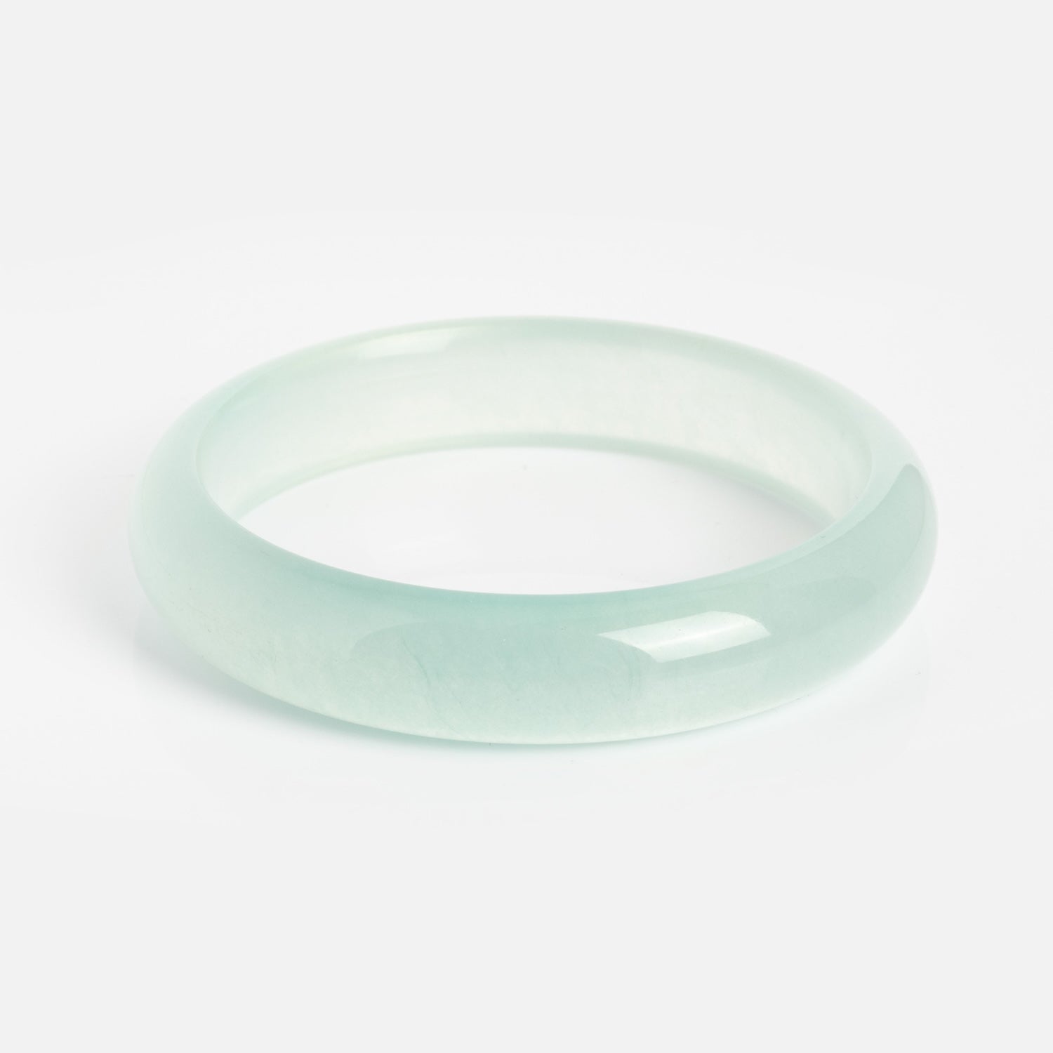 The Pool Blue Jade Stone Bangle, with a smooth polished finish, is displayed on a white background. It measures 13.5 mm in width and has a 2.4-inch opening for comfortable wear.
