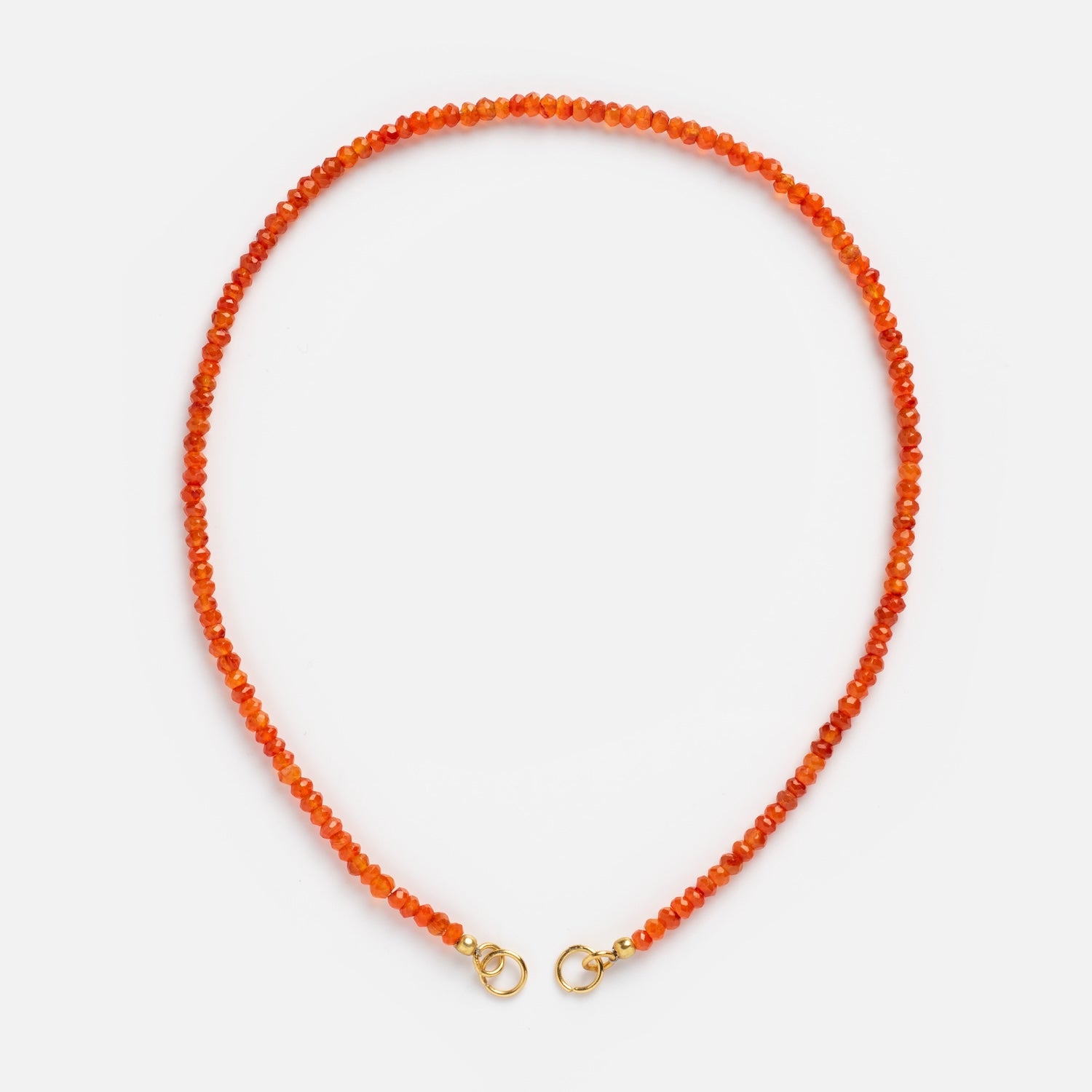 The Customizable Beaded Gemstone Charm Holder Necklace features small, round orange beads and gold lobster claw clasps at each end, beautifully arranged in a circle on a plain white background.