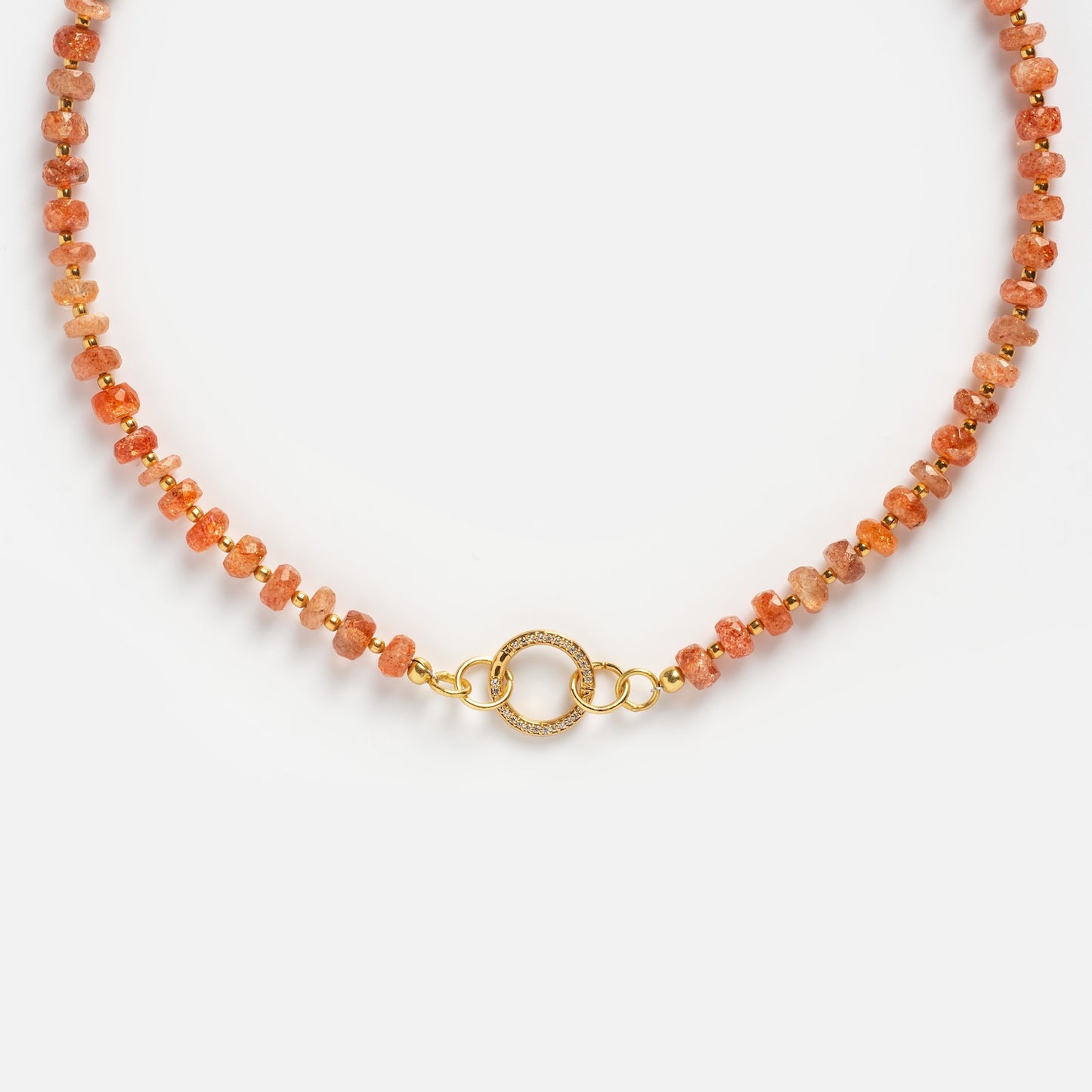 The Customizable Beaded Gemstone Charm Holder Necklace features small, faceted orange stones and a decorative gold clasp with two interlocking circles, displayed against a white background.