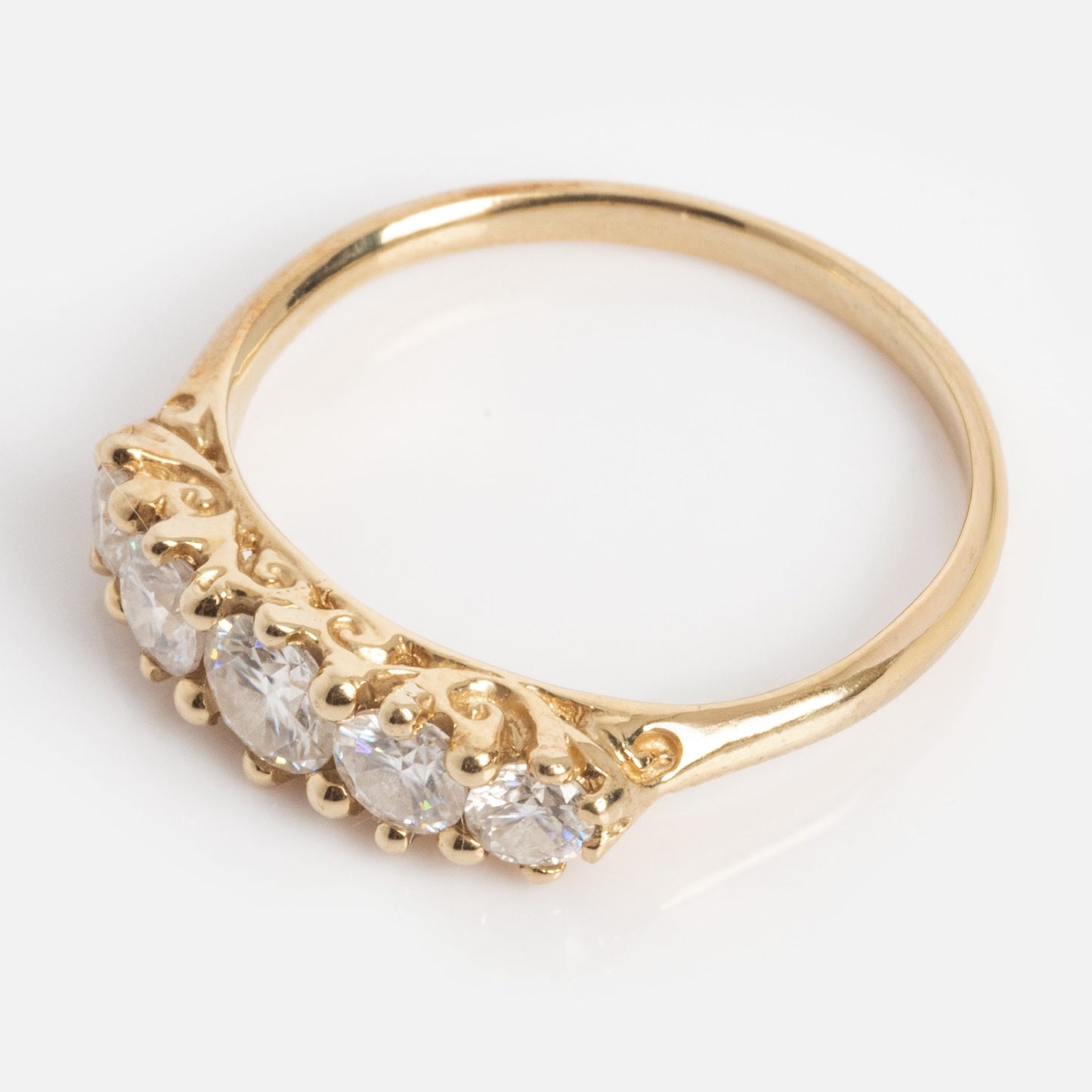 Anniversary Band: A gold ring with five round, clear moissanite stones totaling 0.78 ctw, set in a row on a 1.7 mm band, shown against a white background.