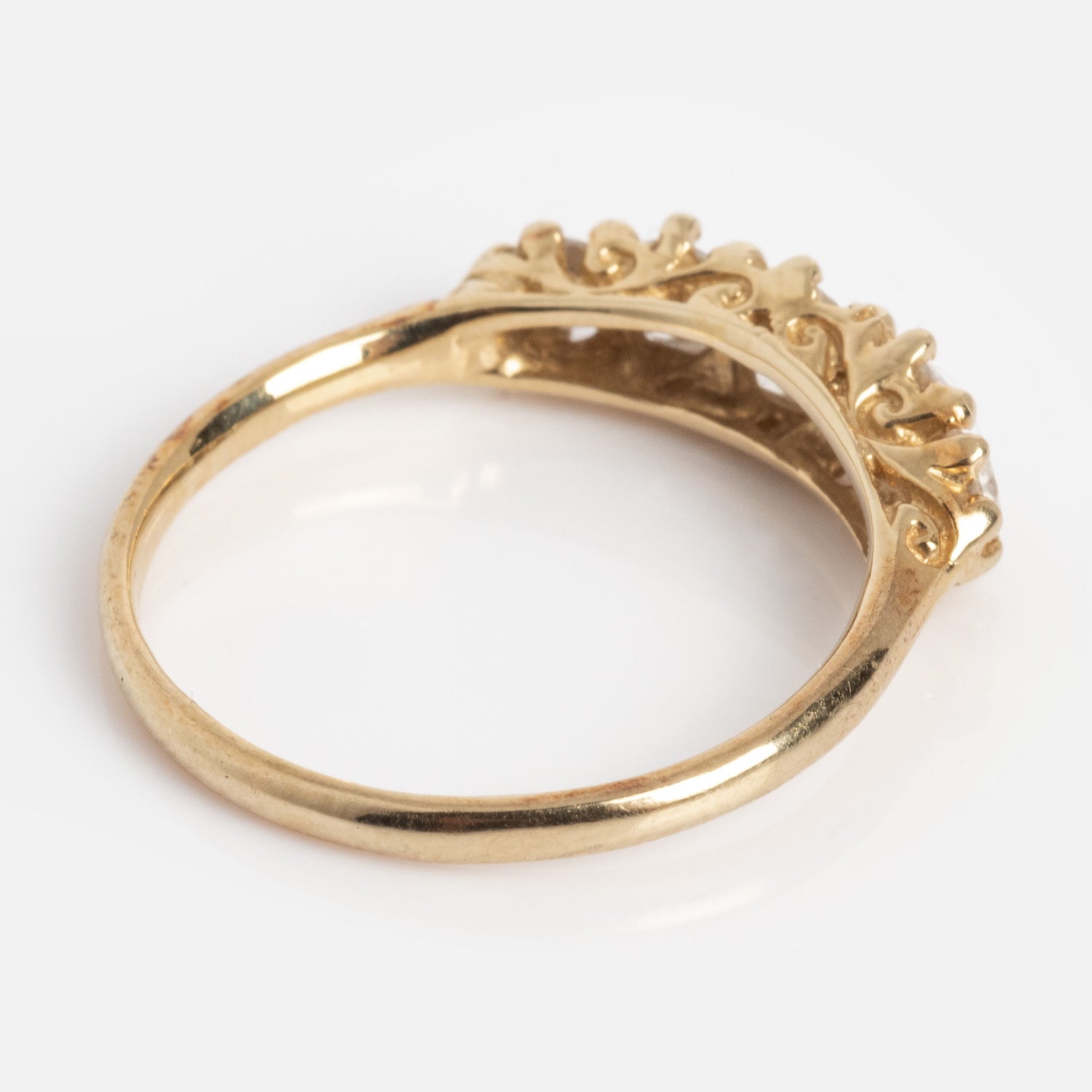 The Anniversary Band is a gold ring with an intricate top design and sparkling moissanite accents, shown from an angled side view on a plain white background. The band width is 1.7 mm.