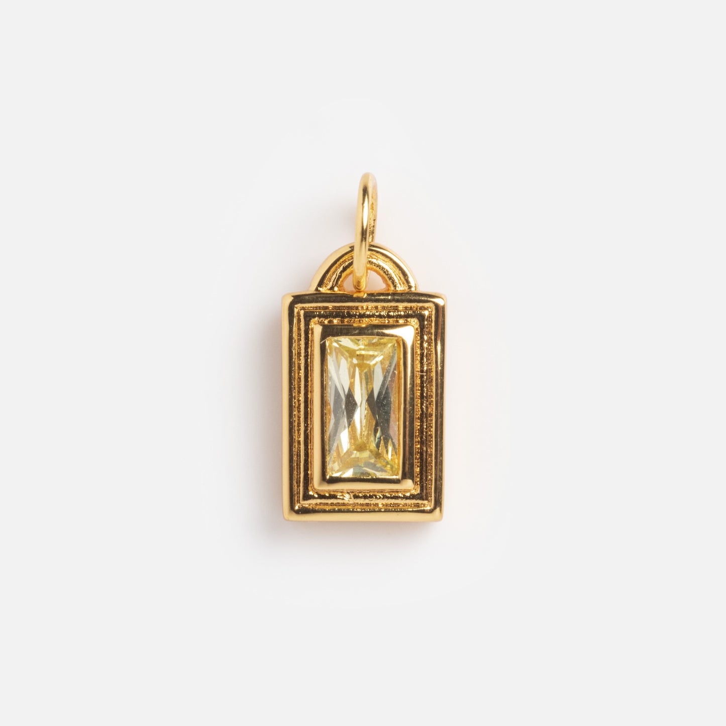 The Monroe Birthstone Charm is a gold rectangular pendant with a geometric frame and a clear, faceted rectangular gemstone at the center, shown against a plain white background.