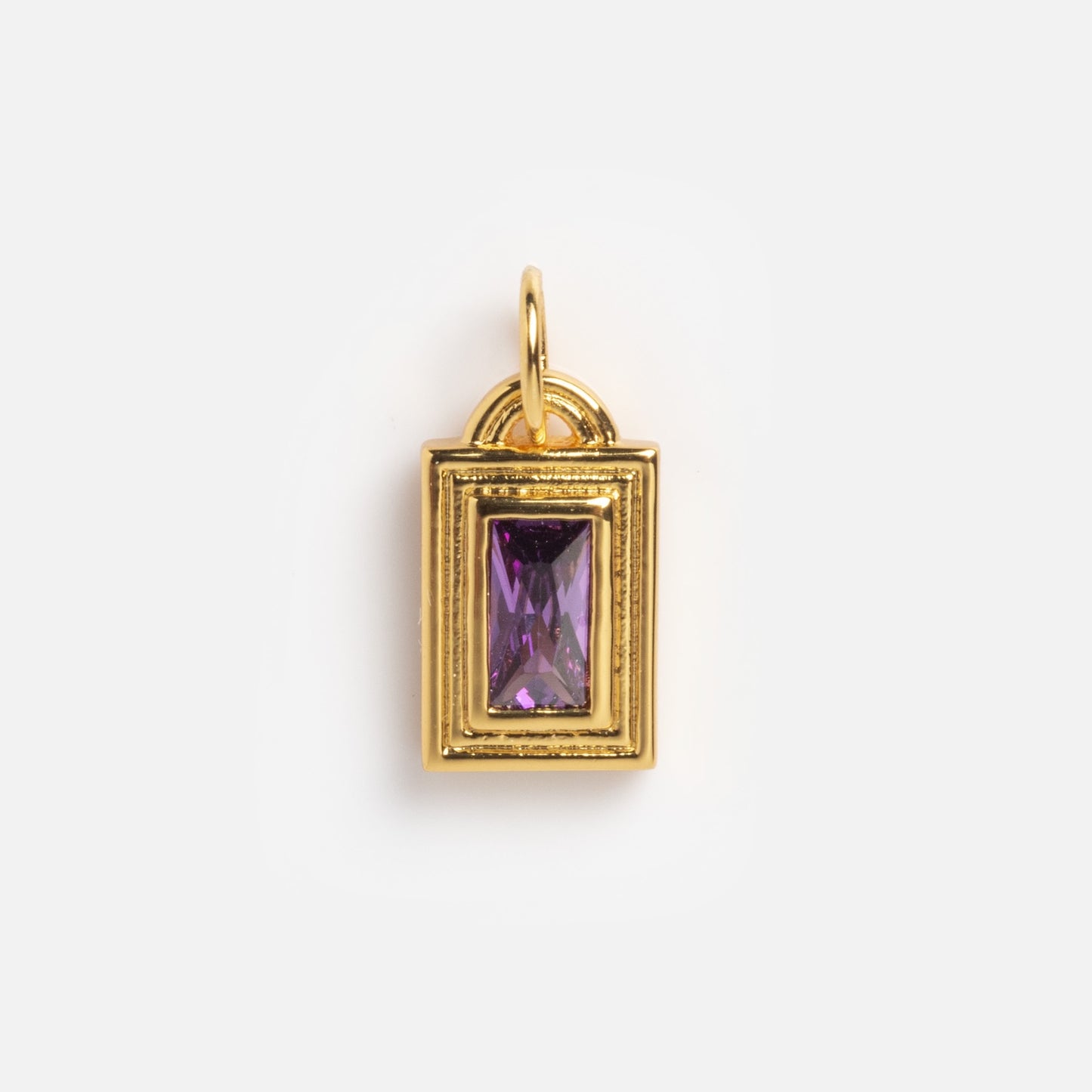 The Monroe Birthstone Charm is a rectangular gold pendant featuring a central purple gemstone and a top loop for attaching to a chain, shown against a plain white background.
