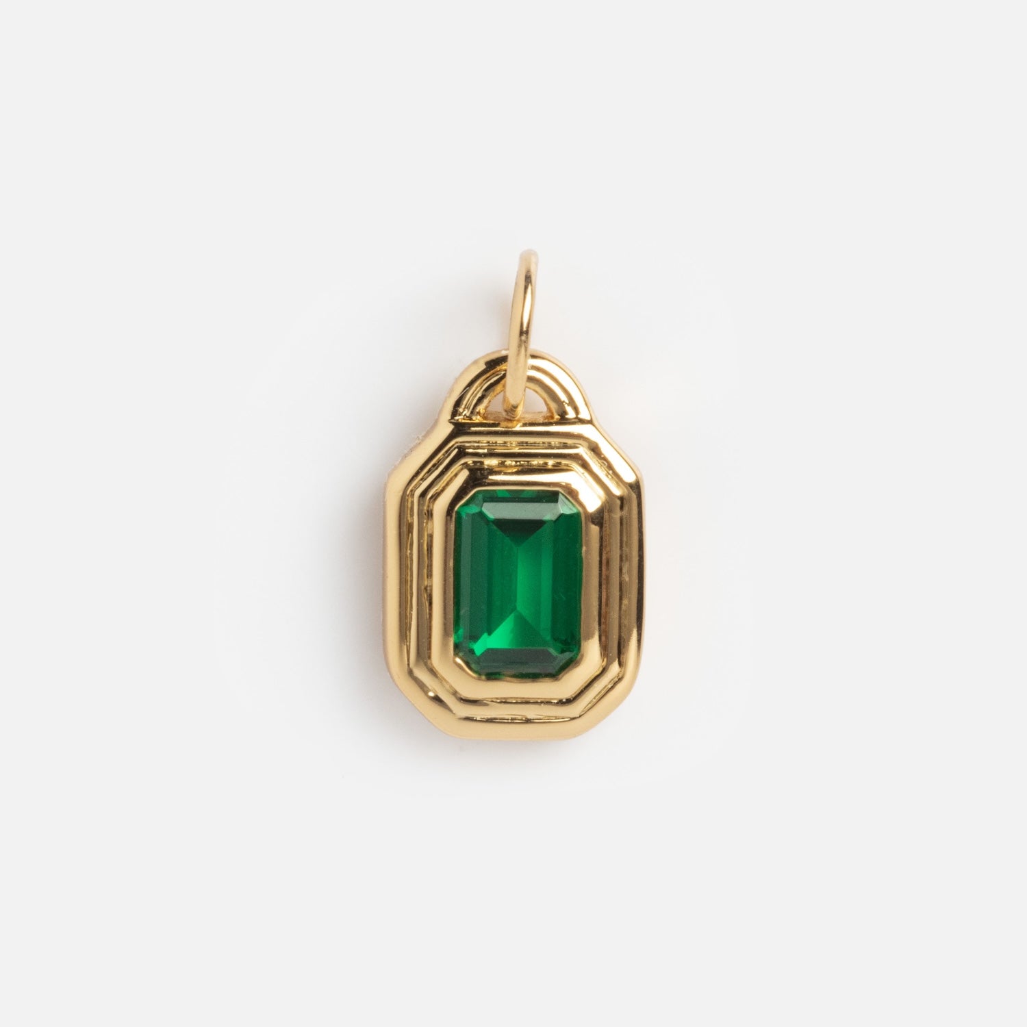 The Monroe Birthstone Charm is a gold pendant with a rectangular green stone set at the center, featuring a beveled gold border and a small loop at the top for attaching to your favorite chain.