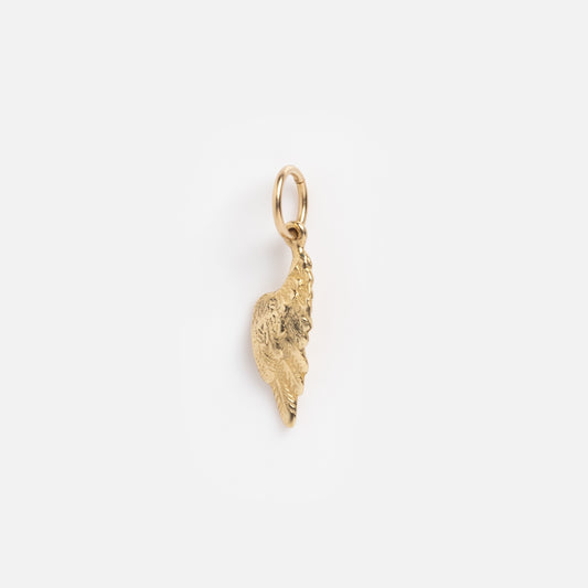 The Charms by Charlie and Marcelle pendant is a small gold angel wing with a textured finish and a circular loop for attaching to a necklace or bracelet, displayed against a plain white background.
