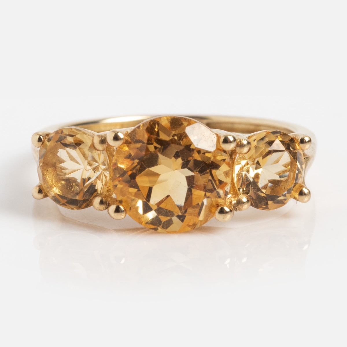 The Solid Gold Trilogy Birthstone Pinky Ring Citrine Sample Size 5 showcases three round Citrine gems, with a larger center stone and two smaller side stones, crafted in 9k solid yellow gold and displayed on a plain white background.