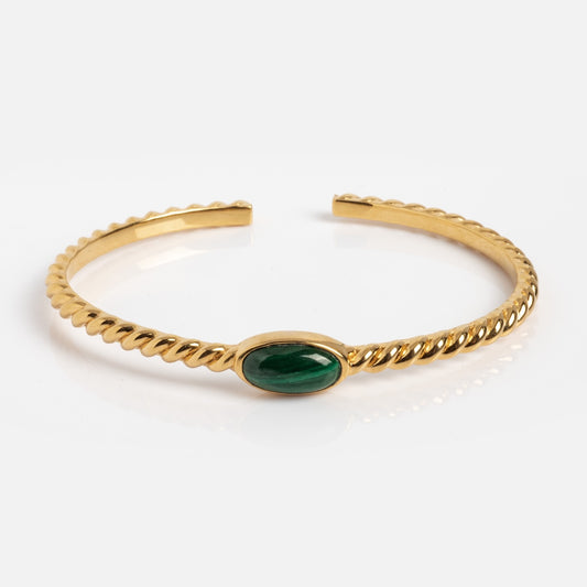 The Malachite Bangle Sample is an 18kt gold twisted open cuff bracelet with a central oval cabochon malachite gemstone, shown on a plain white background.