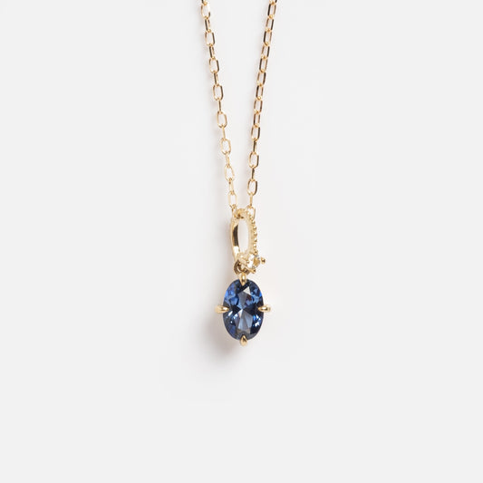 The Solid Gold Vintage Inspired Tanzanite Pendant Necklace Sample features an oval lab tanzanite in a four-prong 9k yellow gold setting, displayed on a plain white background.