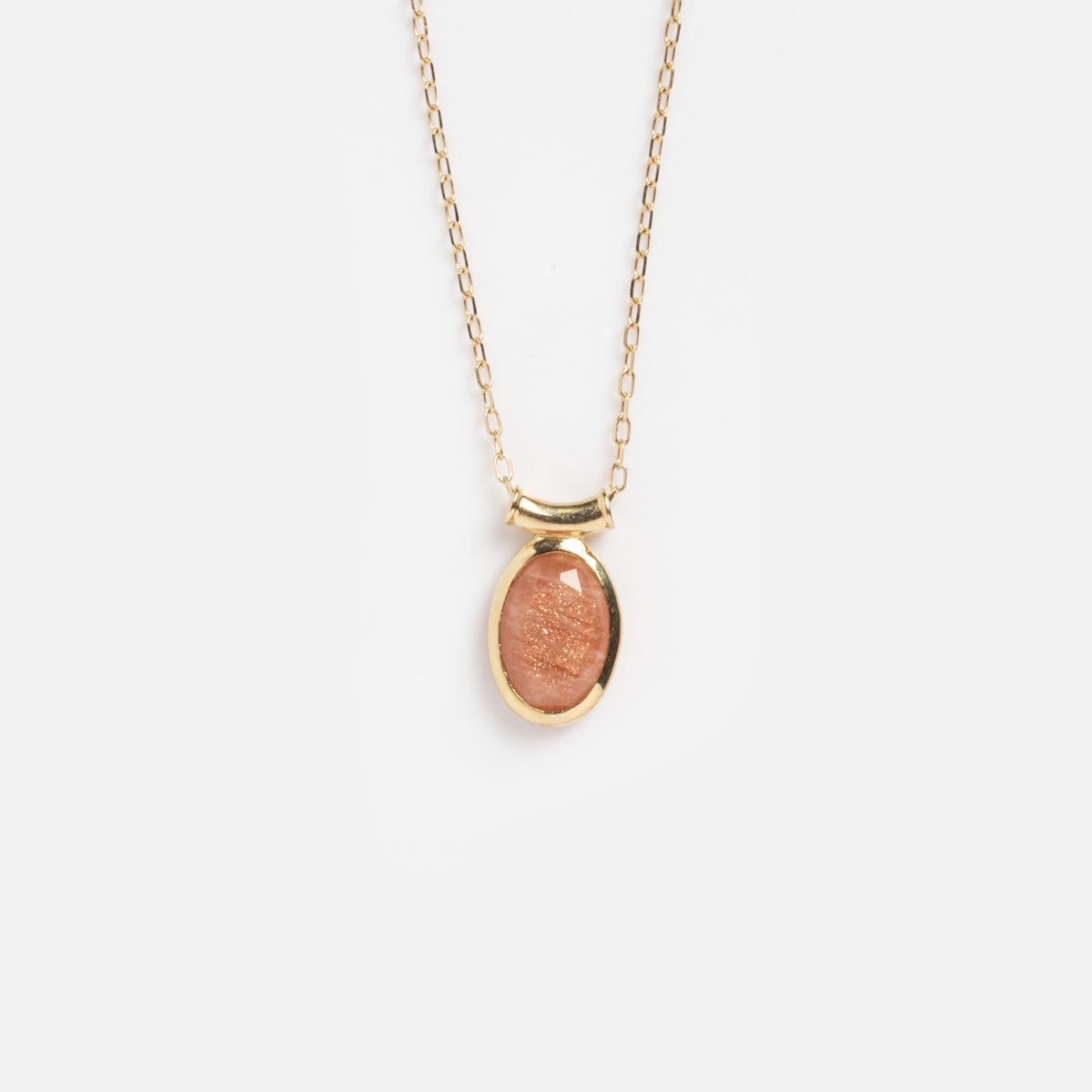 The Solid Gold Sunstone Necklace Sample features a fine 9k gold chain and an oval peach-hued Sunstone pendant, shown against a plain white background.