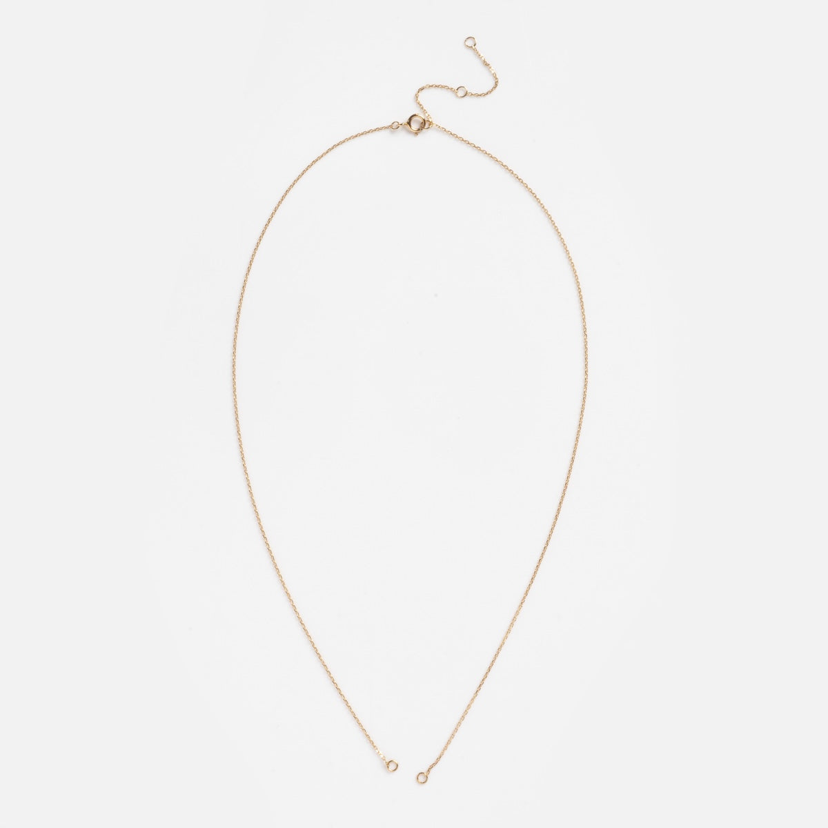 The Solid Gold Perfect Start Charm Holder Delicate Rolo Chain Sample features a small clasp and adjustable extender, displayed in a teardrop shape on a white background.