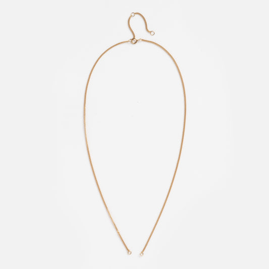 The Solid Gold Perfect Start Charm Holder Curb Chain Sample is a delicate 9k solid gold necklace laid flat on white, forming an elongated oval with small end loops, a charm clip detail, and a hook clasp at the top.
