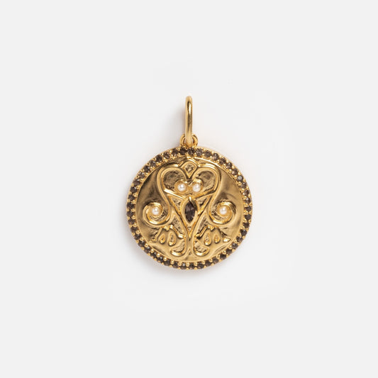 The Pearl Filigree Coin Charm Sample is a round gold pendant with ornate, symmetrical filigree, small raised beads, and a top loop for attaching to a necklace, featuring an elegant vintage-inspired design.