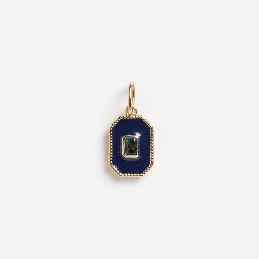 The Solid Gold Deco Black Opal Charm Sample features a rectangular gold pendant with a dark blue-black opal center, accented by a small multi-colored gemstone and finished with a gold border and top loop for attaching to a chain.