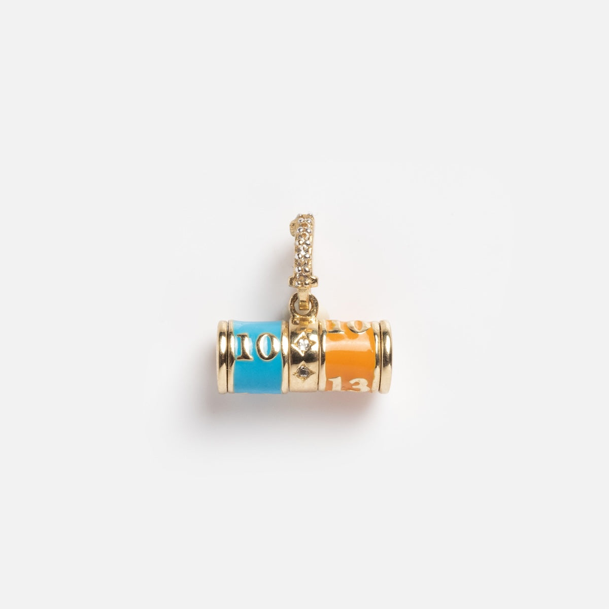 The Solid Gold Lucky Angel Number Spinner Charm Sample is a 9k yellow gold barrel-shaped pendant with blue and orange enamel numbers and a white topaz stone-encrusted loop for attaching to a chain.
